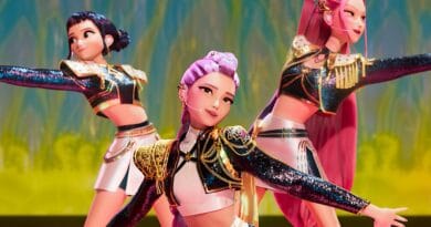 Três personagens femininas animadas com cabelos coloridos dançam no palco com roupas brilhantes e fundo iluminado abstrato.