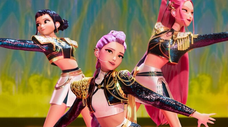 Três personagens femininas animadas com cabelos coloridos dançam no palco com roupas brilhantes e fundo iluminado abstrato.