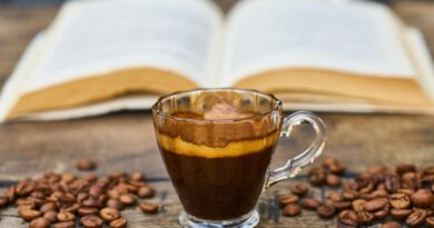 A rich espresso cup surrounded by beans and an open book, perfect for a relaxing break.