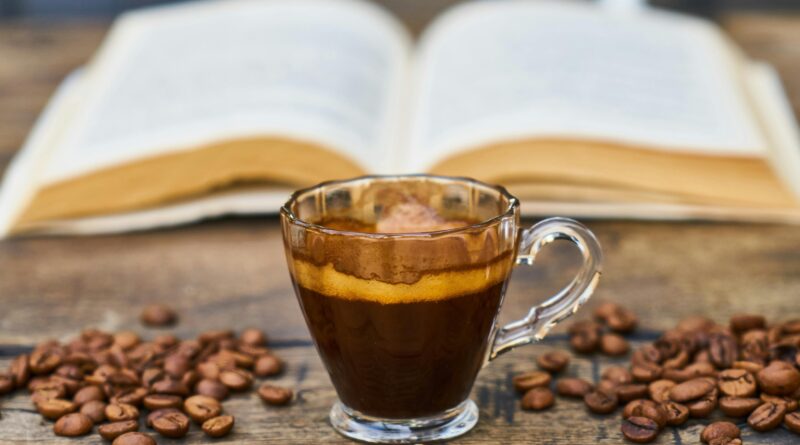 A rich espresso cup surrounded by beans and an open book, perfect for a relaxing break.